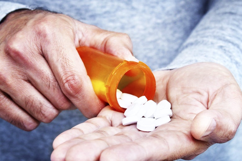 A man pours pills from a bottle into his hand.